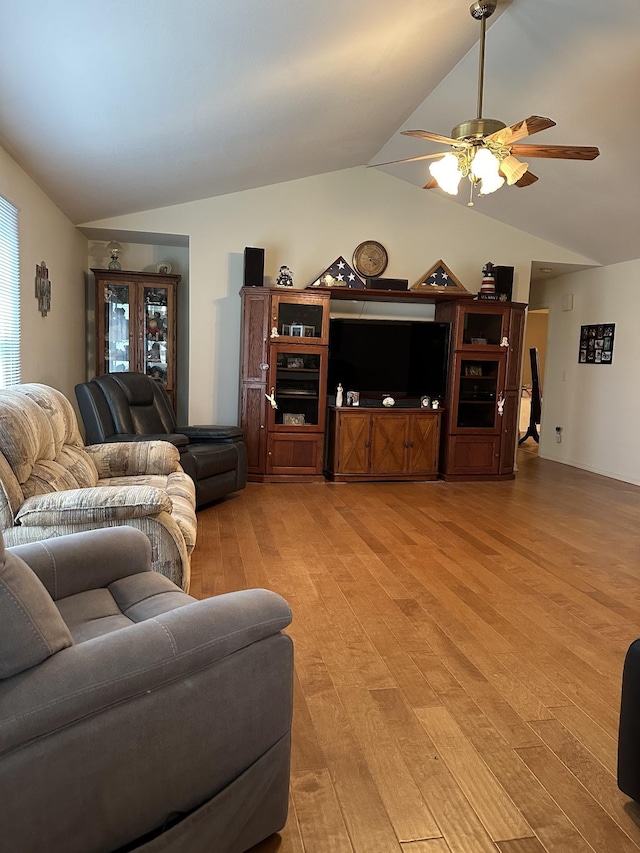 living room featuring light wood-style flooring, a ceiling fan, and vaulted ceiling