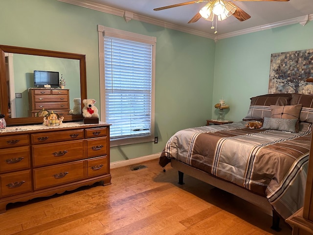 bedroom featuring a ceiling fan, baseboards, light wood finished floors, and ornamental molding