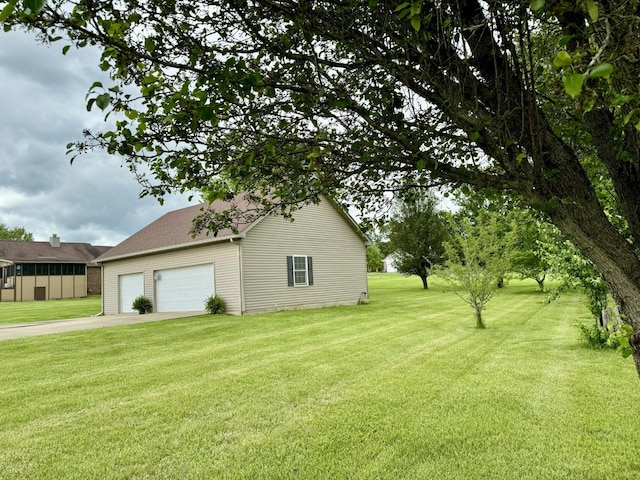 view of yard with a garage and concrete driveway