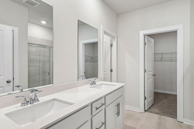 708 Brody Ct, Antioch, TN 37013 - bathroom featuring a walk in closet, double vanity, and a stall shower