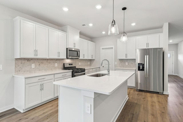 708 Brody Ct, Antioch, TN 37013 - kitchen with stainless steel appliances, white cabinetry, a kitchen island with sink, tasteful backsplash, and wood finished floors