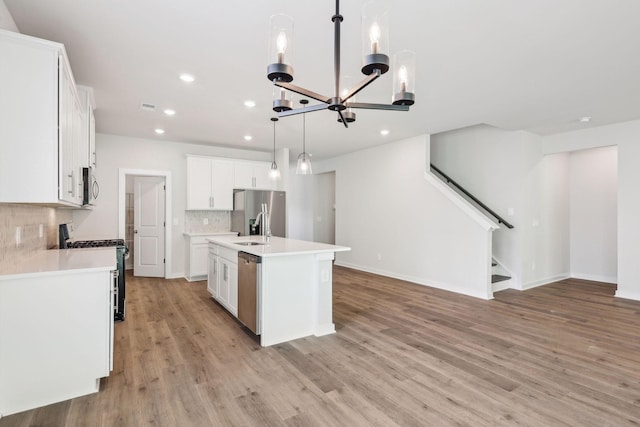 708 Brody Ct, Antioch, TN 37013 - kitchen with appliances with stainless steel finishes, recessed lighting, tasteful backsplash, a chandelier, and light wood-style flooring