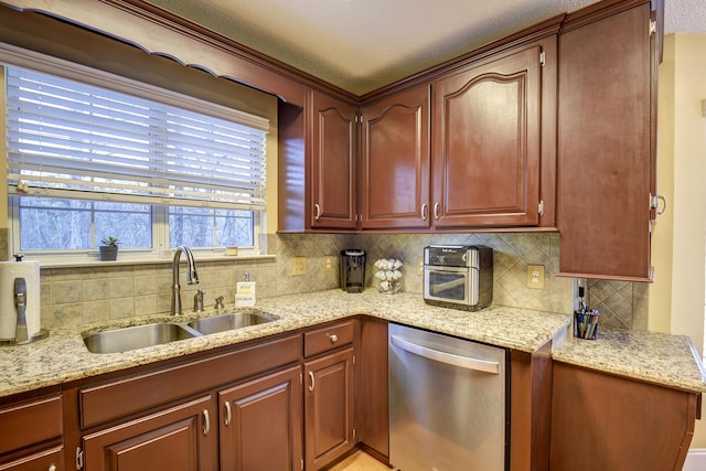 kitchen featuring dishwasher, light stone countertops, and a sink