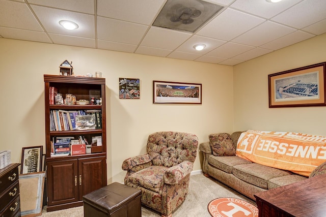 carpeted living room featuring a paneled ceiling