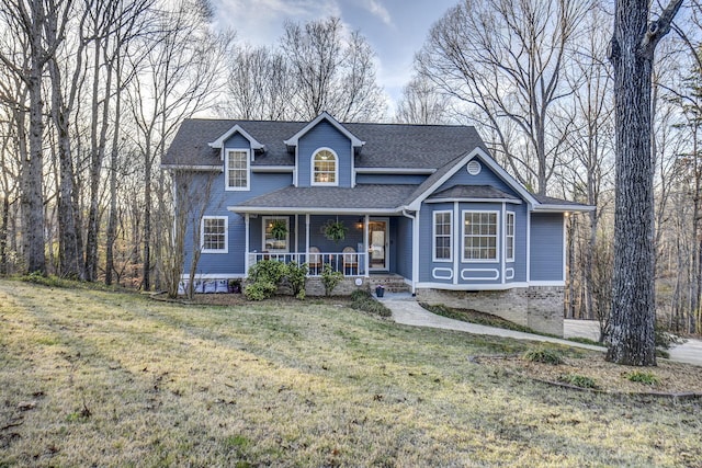 view of front of house featuring a porch, a front lawn, and a shingled roof