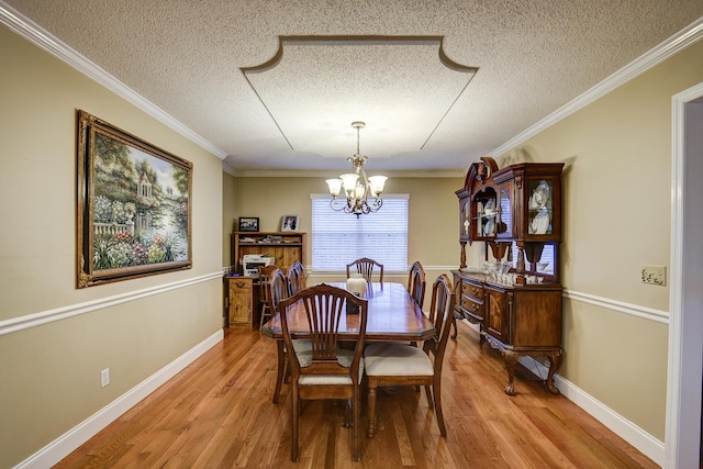 dining room featuring crown molding, wood finished floors, baseboards, and a chandelier