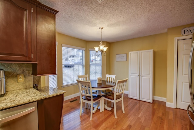 dining space featuring a notable chandelier, visible vents, baseboards, and light wood-style floors