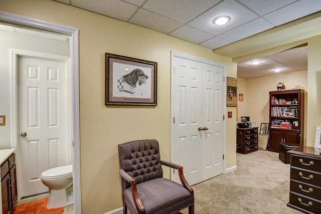 sitting room featuring light colored carpet, baseboards, and a paneled ceiling