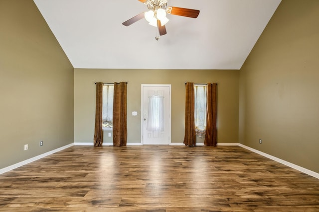 empty room featuring baseboards, lofted ceiling, wood finished floors, and a ceiling fan