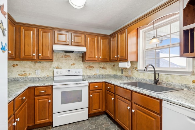 kitchen with white appliances, brown cabinetry, under cabinet range hood, and a sink