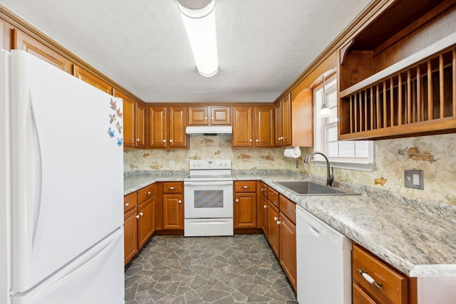 kitchen featuring white appliances, brown cabinetry, under cabinet range hood, and a sink