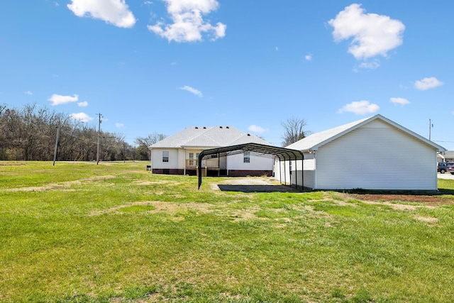 back of property featuring a detached carport and a lawn