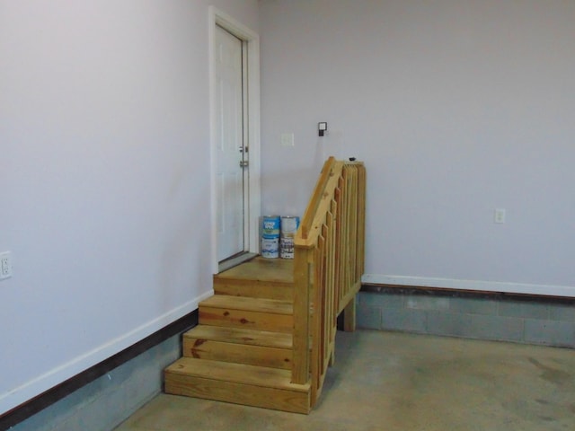 stairway featuring concrete flooring