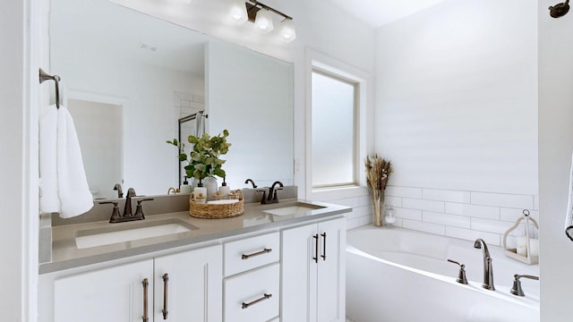 5020 E Mayflower Ct, Greenbrier, TN 37073 - full bathroom with a garden tub, double vanity, a shower stall, and a sink