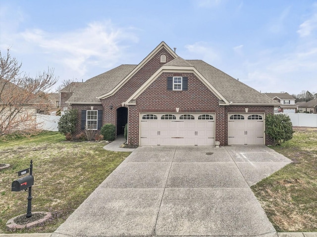 1060 Campbell Ave, Gallatin, TN 37066 - view of front facade with brick siding, a front lawn, fence, concrete driveway, and roof with shingles