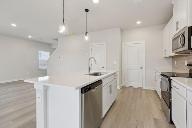 4220 Skyridge Dr, Nashville, TN 37207 - kitchen with stainless steel appliances, a sink, light wood-style floors, light countertops, and an island with sink