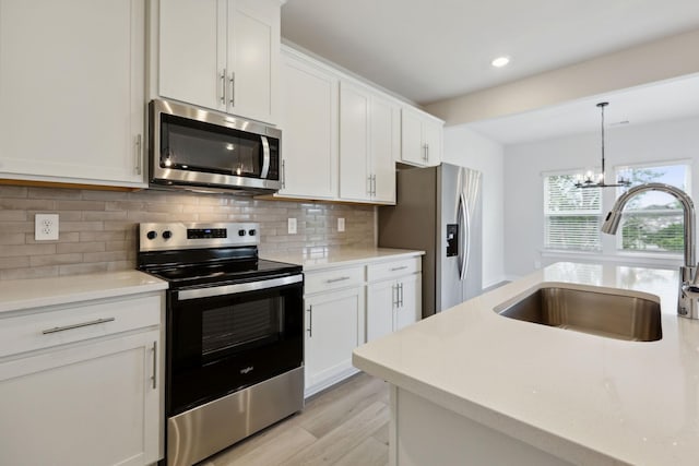 4220 Skyridge Dr, Nashville, TN 37207 - kitchen with appliances with stainless steel finishes, a sink, a chandelier, light countertops, and decorative backsplash