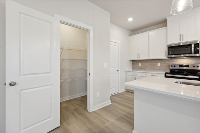4220 Skyridge Dr, Nashville, TN 37207 - kitchen with stainless steel microwave, range with electric cooktop, light countertops, light wood-type flooring, and backsplash