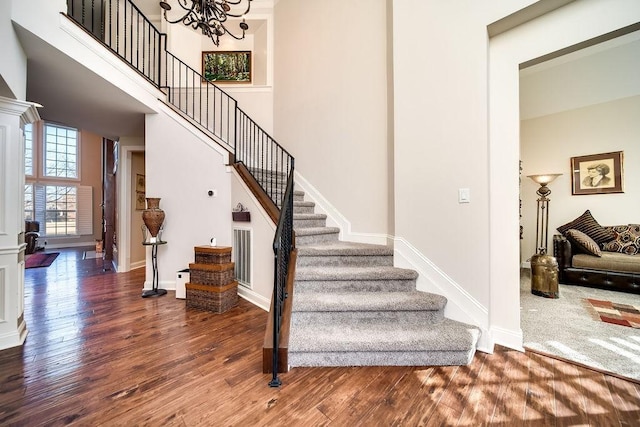 908 Plantation Blvd, Gallatin, TN 37066 - stairway featuring baseboards, a notable chandelier, wood finished floors, and a towering ceiling