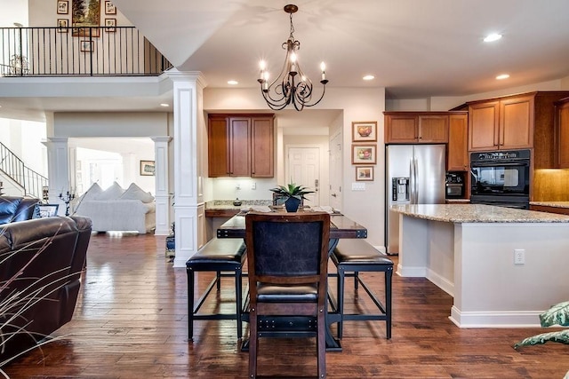 908 Plantation Blvd, Gallatin, TN 37066 - kitchen with dark wood-type flooring, open floor plan, decorative columns, brown cabinets, and stainless steel refrigerator with ice dispenser