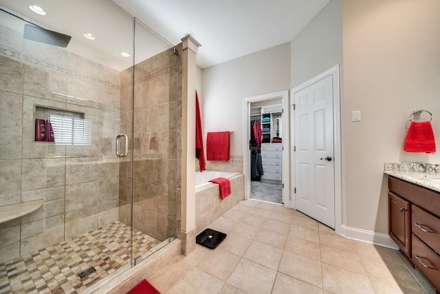 908 Plantation Blvd, Gallatin, TN 37066 - bathroom with tile patterned floors, a walk in closet, a stall shower, tiled bath, and vanity