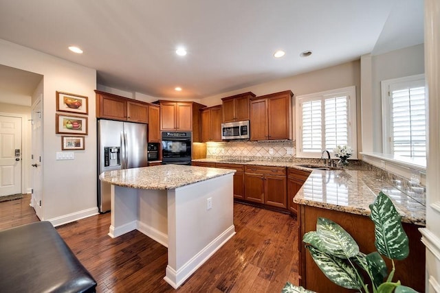 908 Plantation Blvd, Gallatin, TN 37066 - kitchen with black appliances, brown cabinetry, dark wood-type flooring, and a sink