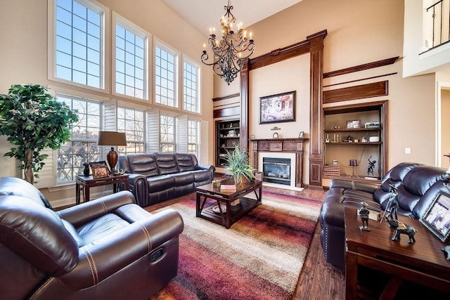 908 Plantation Blvd, Gallatin, TN 37066 - living room with built in features, a fireplace, an inviting chandelier, wood finished floors, and a towering ceiling