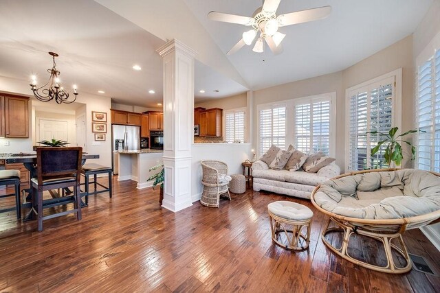 908 Plantation Blvd, Gallatin, TN 37066 - living room featuring ceiling fan with notable chandelier, vaulted ceiling, dark wood-style flooring, and ornate columns