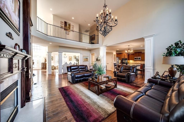 908 Plantation Blvd, Gallatin, TN 37066 - living room featuring a chandelier, a premium fireplace, wood finished floors, and decorative columns