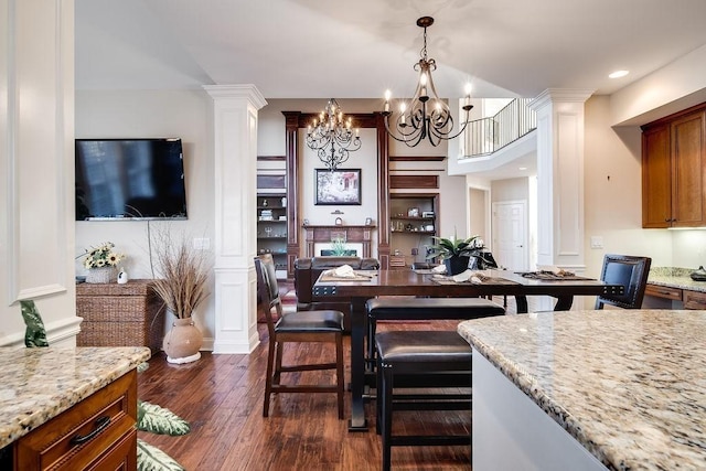 908 Plantation Blvd, Gallatin, TN 37066 - kitchen with a chandelier, brown cabinets, ornate columns, and dark wood-style flooring