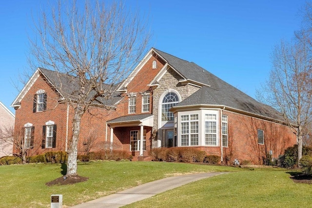 908 Plantation Blvd, Gallatin, TN 37066 - traditional home featuring stone siding, brick siding, roof with shingles, and a front lawn
