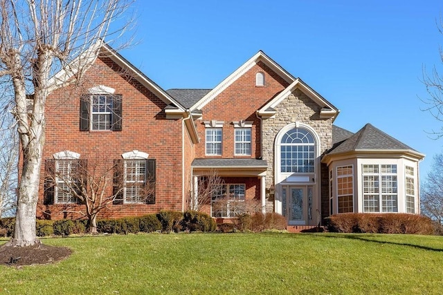908 Plantation Blvd, Gallatin, TN 37066 - traditional home with a front yard, brick siding, and roof with shingles