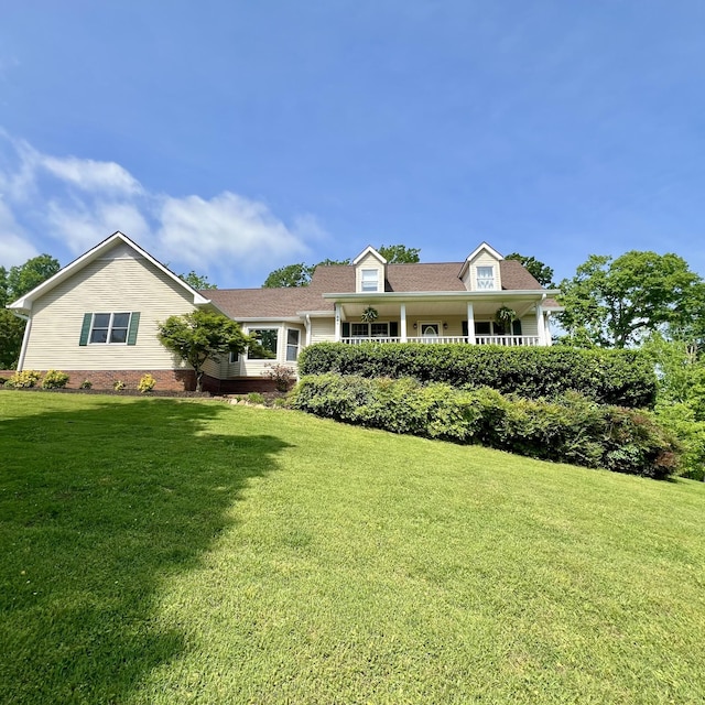 view of front of property with a porch and a front lawn