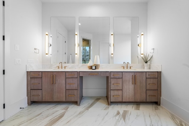 full bath featuring a sink, marble finish floor, baseboards, and double vanity