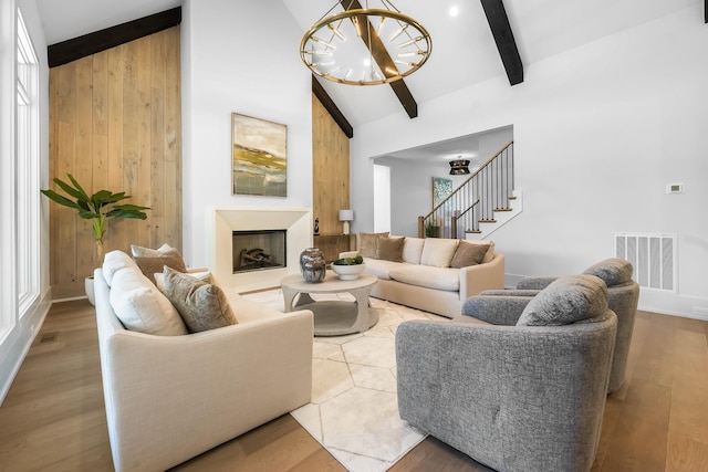 living room featuring visible vents, beamed ceiling, high vaulted ceiling, wood finished floors, and a chandelier