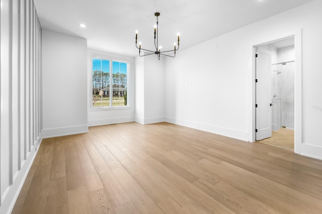 unfurnished dining area featuring an inviting chandelier, recessed lighting, light wood-style floors, and baseboards