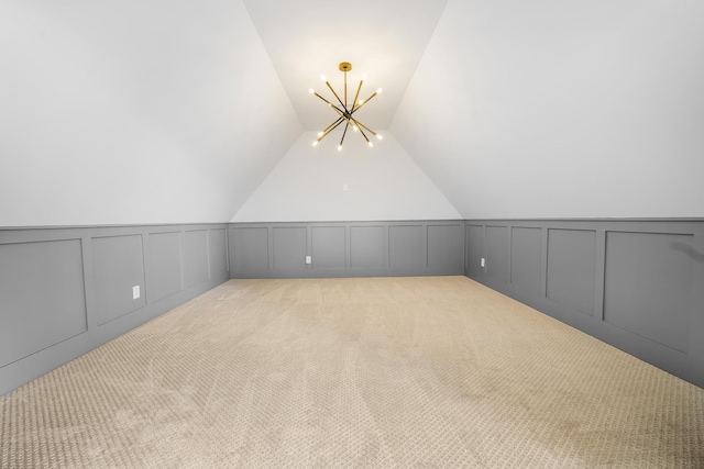 bonus room featuring lofted ceiling, light colored carpet, and a decorative wall