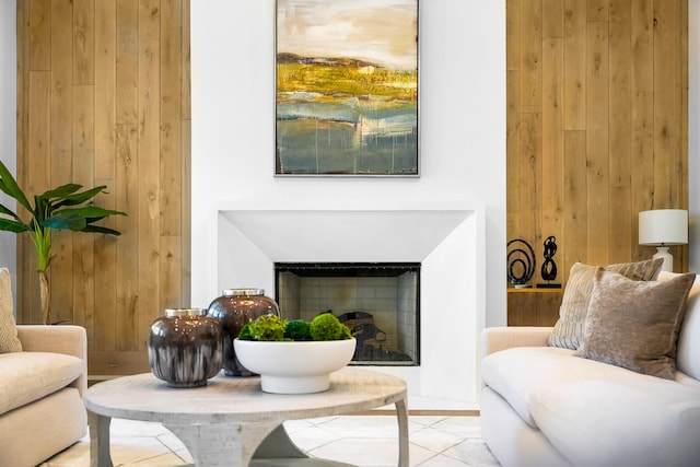 sitting room with wood walls and a fireplace