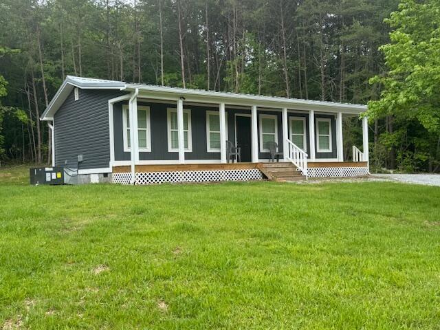 4539 Toestring Valley Rd, Spring City, TN 37381 - manufactured / mobile home featuring a wooded view, metal roof, covered porch, crawl space, and a front lawn