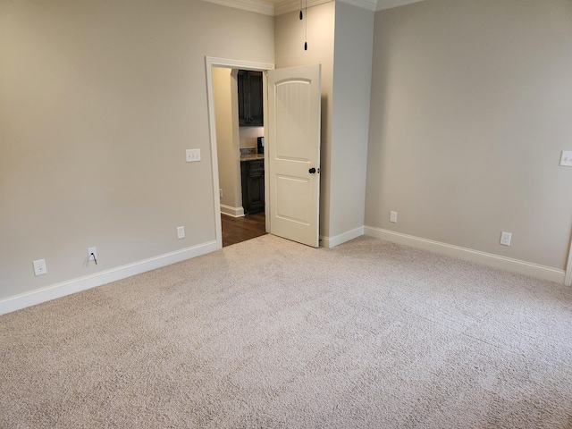 carpeted empty room with baseboards and ornamental molding