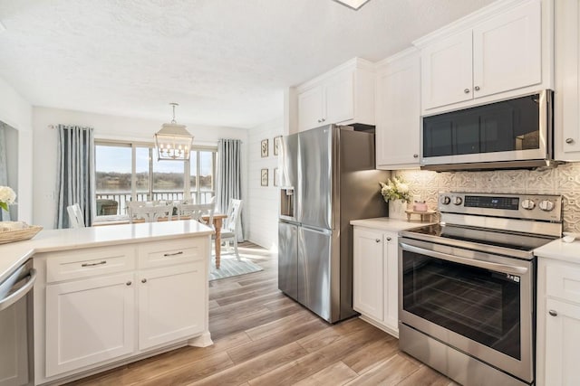 144 Tanasi Shr, Gallatin, TN 37066 - kitchen with a notable chandelier, light wood-style flooring, stainless steel appliances, white cabinets, and light countertops
