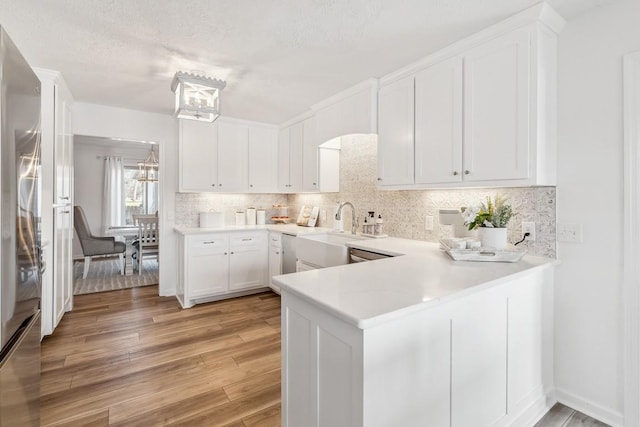 144 Tanasi Shr, Gallatin, TN 37066 - kitchen with tasteful backsplash, a chandelier, light wood-type flooring, stainless steel fridge, and white cabinetry