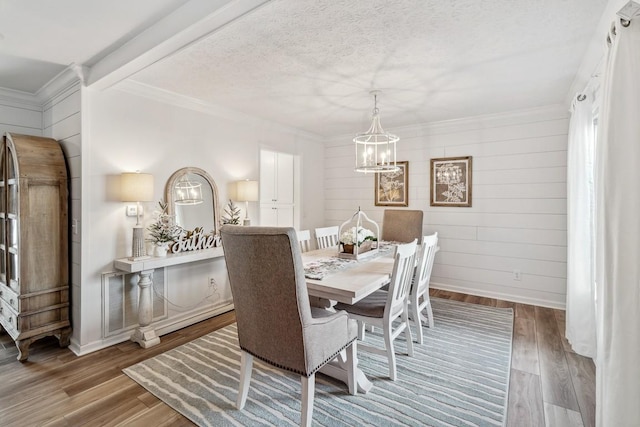 144 Tanasi Shr, Gallatin, TN 37066 - dining space featuring crown molding, baseboards, wood finished floors, a notable chandelier, and a textured ceiling