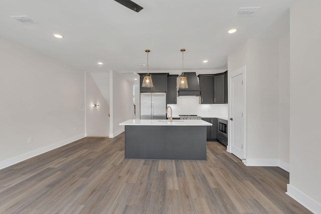 1016 W Kirkland Ave Unit C, Nashville, TN 37216 - kitchen with premium range hood, a kitchen island with sink, a sink, appliances with stainless steel finishes, and tasteful backsplash