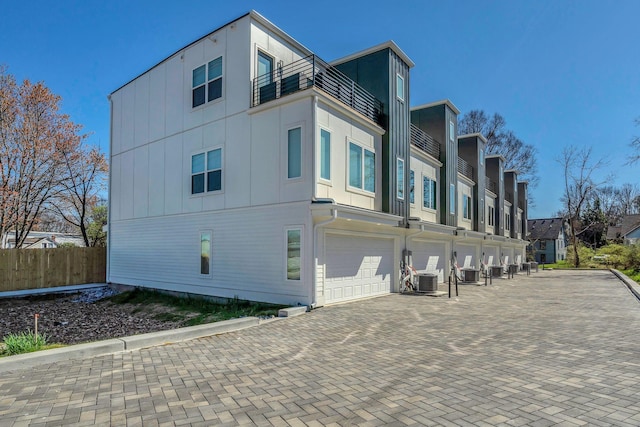 1016 W Kirkland Ave Unit C, Nashville, TN 37216 - view of side of property featuring driveway, central AC, fence, a garage, and a balcony