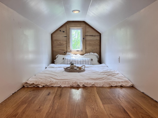 bedroom with wood finished floors and vaulted ceiling