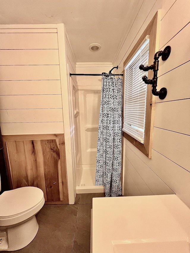 full bath featuring crown molding, toilet, wood walls, and a shower with shower curtain