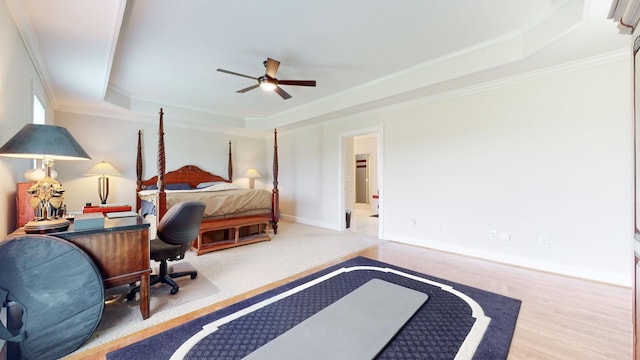bedroom with a raised ceiling, crown molding, baseboards, and ceiling fan