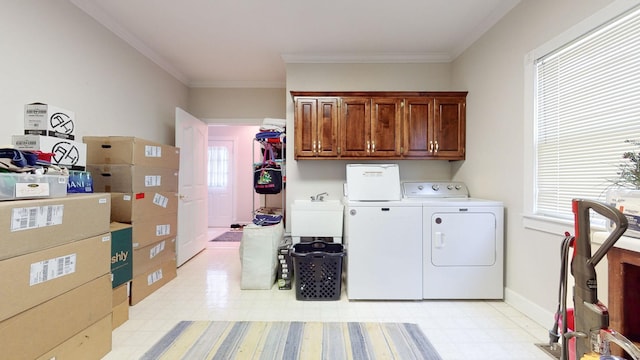 laundry room featuring crown molding, light floors, separate washer and dryer, cabinet space, and a sink