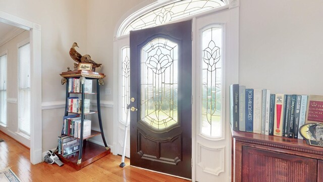 entryway with baseboards, a healthy amount of sunlight, and light wood finished floors